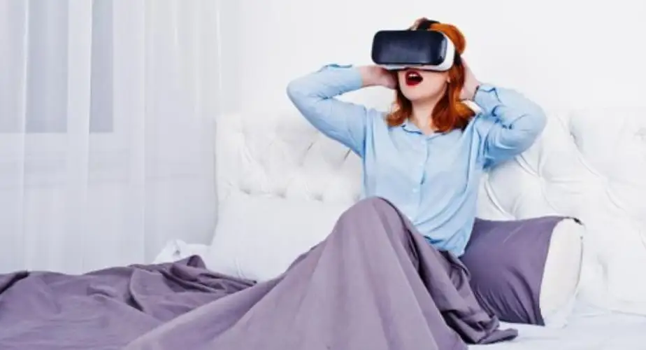 red haired girl in bed with sex vr glasses