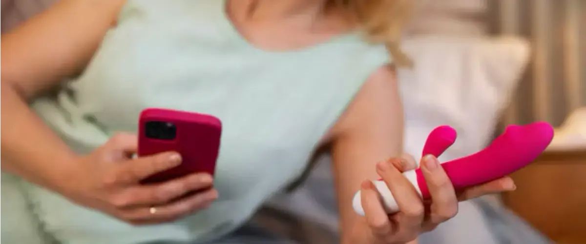woman using a remote control vibrator by smartphone